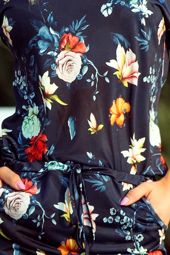 Sportinė suknelė su ryškiu gėlių raštu ant tamsiai mėlyno fono suteikia elegancijos ir žaismingumo. Suknelė turi patogų raištelį ties juosmeniu, pabrėžiantį figūrą.