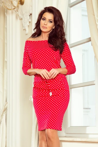 Raudona suknelė su baltais taškeliais ir trijų ketvirčių rankovėmis suteikia elegancijos ir žaismingumo. Suknelė turi subtilų juosmens raištelį, kuris pabrėžia figūrą.}