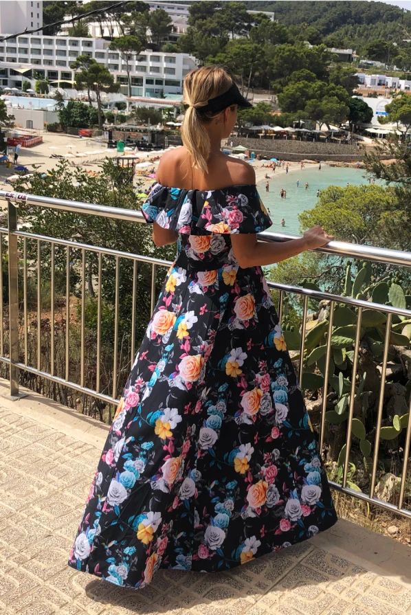 Ilga suknelė su ispanišku kirpimu, dekoruota ryškiais gėlių raštais. Suknelė puikiai tinka vasaros progoms, suteikianti elegancijos ir lengvumo pojūtį.