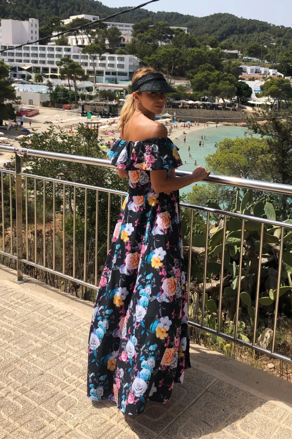 Ilga suknelė su ispanišku kirpimu, dekoruota spalvingais gėlių raštais, suteikia elegancijos ir vasariško žavesio. Suknelė puikiai tinka šiltoms dienoms, pabrėžiant moteriškumą ir stiliaus pojūtį.