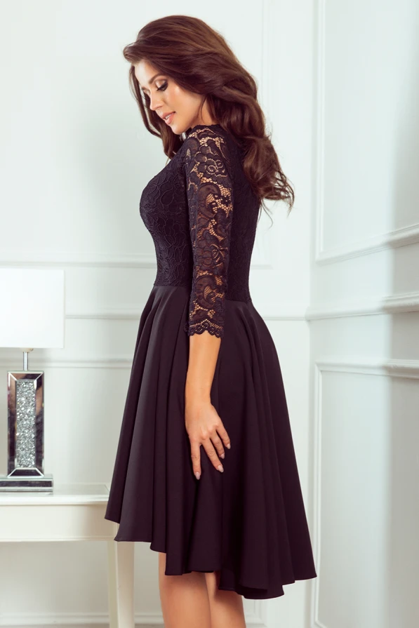 Elegantiška juoda suknelė su nėriniuota viršutine dalimi ir trijų ketvirčių rankovėmis. Suknelė turi platų, lengvai krentantį sijoną, suteikiantį grakštumo ir moteriškumo.