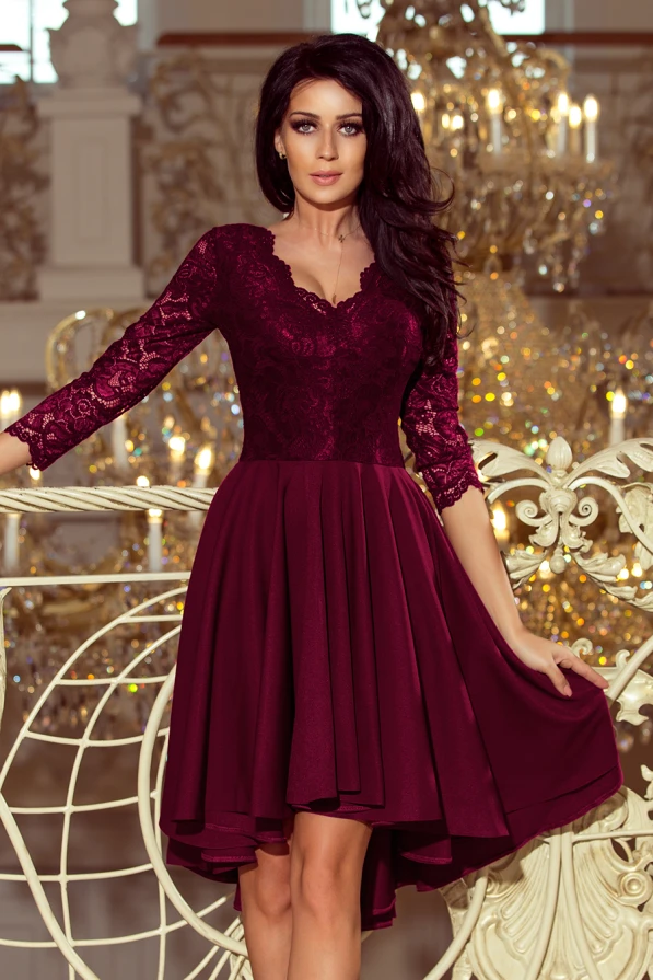 Elegantiška bordo spalvos suknelė su nėriniuota viršutine dalimi ir trijų ketvirčių rankovėmis. Suknelė turi asimetrišką sijoną, kuris suteikia žavesio ir puošnumo.