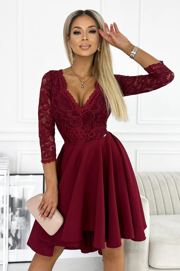 Elegantiška bordo spalvos suknelė su nėriniuota viršutine dalimi ir trijų ketvirčių rankovėmis. Suknelė turi platų, lengvai krentantį sijoną, kuris suteikia grakštumo ir puošnumo.
