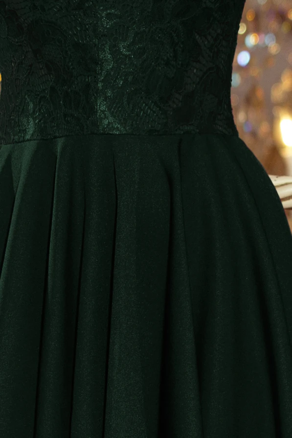 Elegantiška tamsiai žalia suknelė su nėrinių viršumi ir lengvai krentančiu sijonu. Suknelė puikiai tinka ypatingoms progoms, suteikianti rafinuotumo ir žavesio.