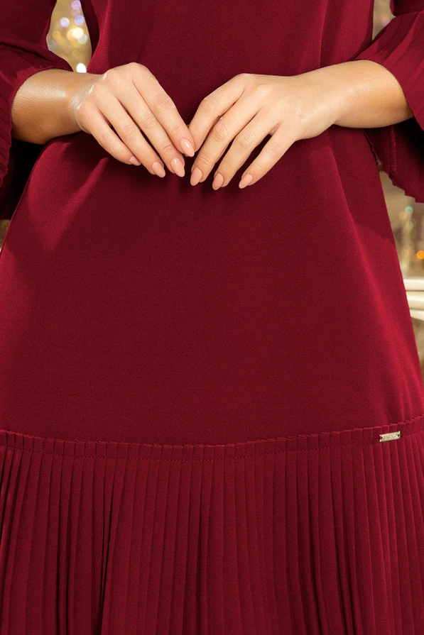 Elegantiška bordo spalvos suknelė su plisuota apačia ir plačiomis rankovėmis. Suknelė pasižymi subtiliu dizainu, puikiai tinkančiu tiek kasdienai, tiek ypatingoms progoms.