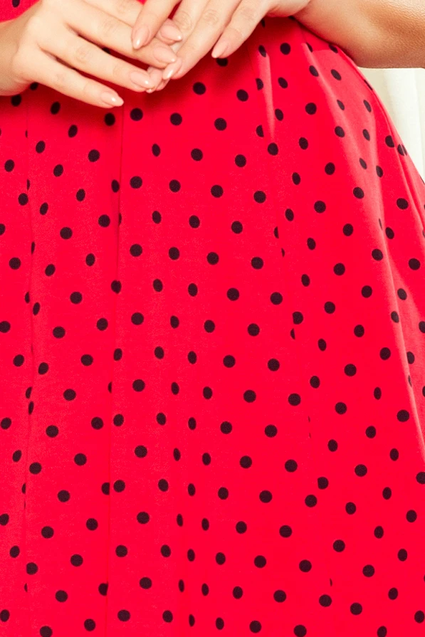 Raudona suknelė su juodais taškeliais, suteikianti žaismingumo ir elegancijos. Suknelė yra platėjanti, puikiai tinkanti įvairioms progoms.