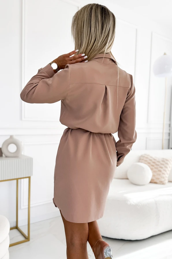 Moteriška suknelė su marškinių tipo viršumi, pasiūta iš švelnios smėlio spalvos audinio. Suknelė turi elegantišką apykaklę ir subtilų juosmens akcentą, puikiai tinka kasdieniam ar biuro stiliui.
