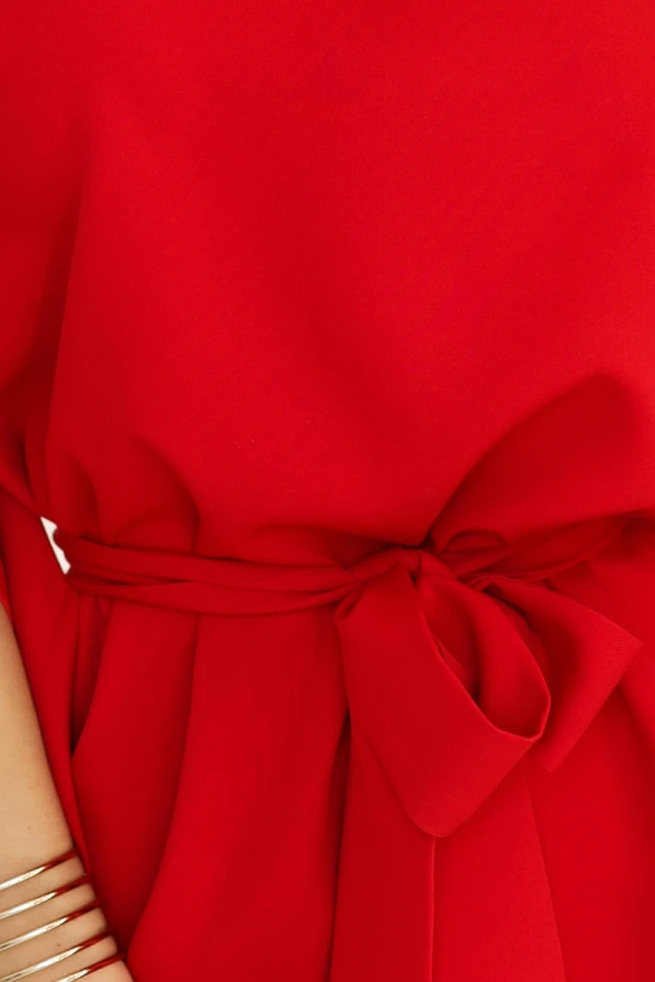 Ryškiai raudona suknelė su elegantišku kaspinu ties juosmeniu suteikia išskirtinį ir moterišką įvaizdį. Audinys švelniai krenta, pabrėždamas subtilų dizainą ir kokybę.