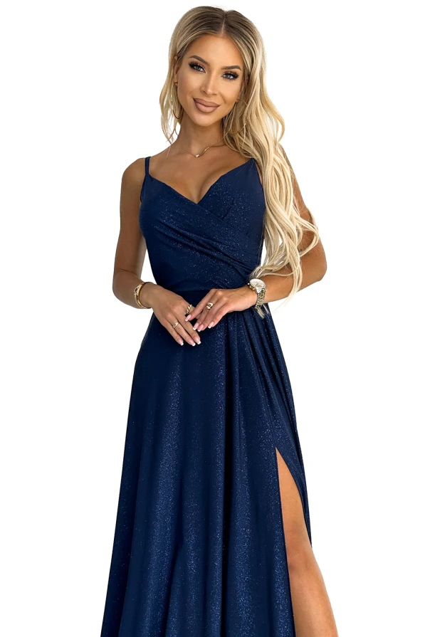 Eleganti tamsiai mėlyna maxi suknelė su blizgučiais ir subtiliomis petnešėlėmis suteikia prabangos įspūdį. Suknelė turi elegantišką skeltuką, kuris suteikia žavesio ir rafinuotumo.