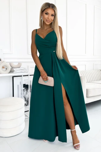 Elegantiška ilga suknelė su plonu dirželiu ir subtiliu skeltuku, puikiai tinkanti ypatingoms progoms. Suknelė pasižymi sodria smaragdo spalva ir elegantišku dizainu, kuris pabrėžia moteriškumą.}