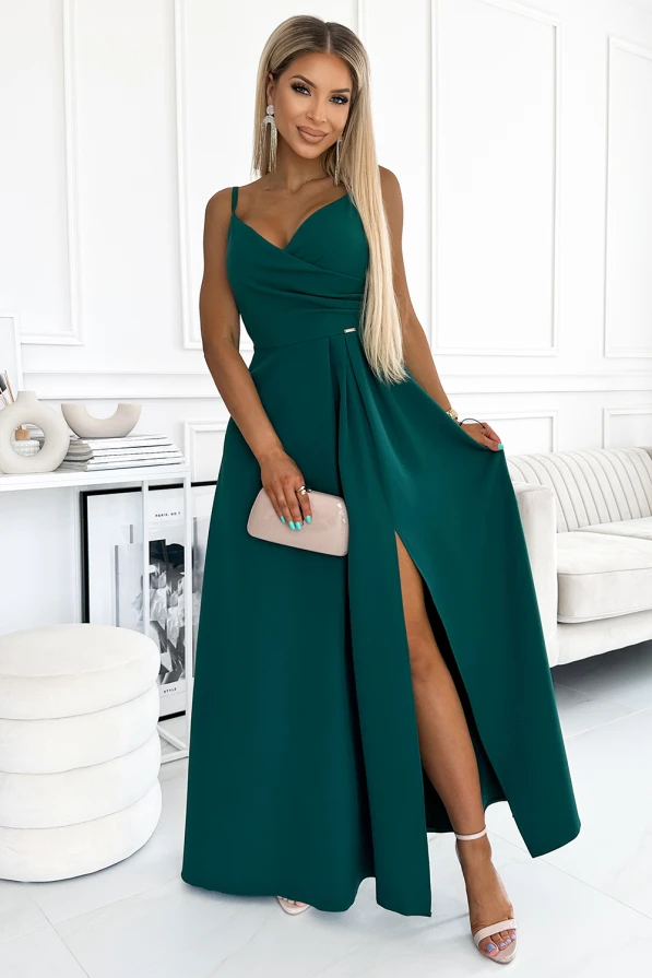Elegantiška ilga suknelė su plonu dirželiu ir subtiliu skeltuku, puikiai tinkanti ypatingoms progoms. Suknelė pasižymi sodria smaragdo spalva ir elegantišku dizainu, kuris pabrėžia moteriškumą.