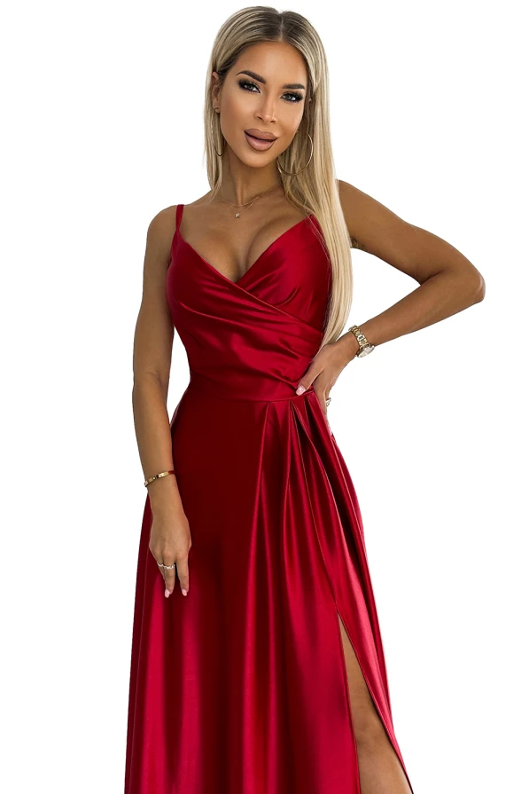 Elegantiška raudona maxi suknelė su plonomis petnešėlėmis ir subtiliu klostavimu ties liemeniu. Suknelė turi aukštą skeltuką, suteikiantį žavesio ir elegancijos.