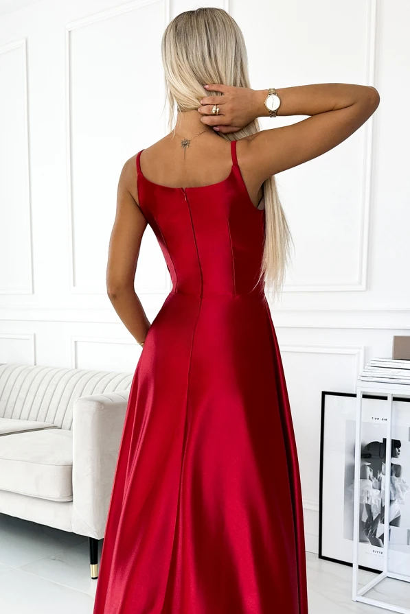 Elegantiška raudona maxi suknelė su plonomis petnešėlėmis ir subtiliu blizgesiu. Suknelė puikiai tinka ypatingoms progoms, suteikianti rafinuotumo ir elegancijos.