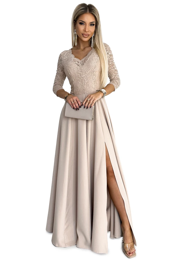Elegantiška ilga suknelė su nėriniuota viršutine dalimi ir trijų ketvirčių rankovėmis, subtiliai pabrėžianti moteriškumą. Suknelė turi elegantišką skeltuką, suteikiantį rafinuotumo ir judėjimo laisvės.