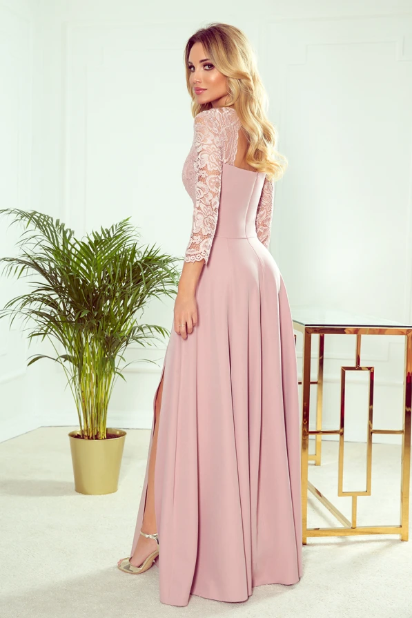 Elegantiška ilga suknelė su nėrinių viršumi ir trijų ketvirčių rankovėmis, subtiliai pabrėžianti moterišką siluetą. Suknelė turi elegantišką skeltuką, suteikiantį judesiui lengvumo ir grakštumo.