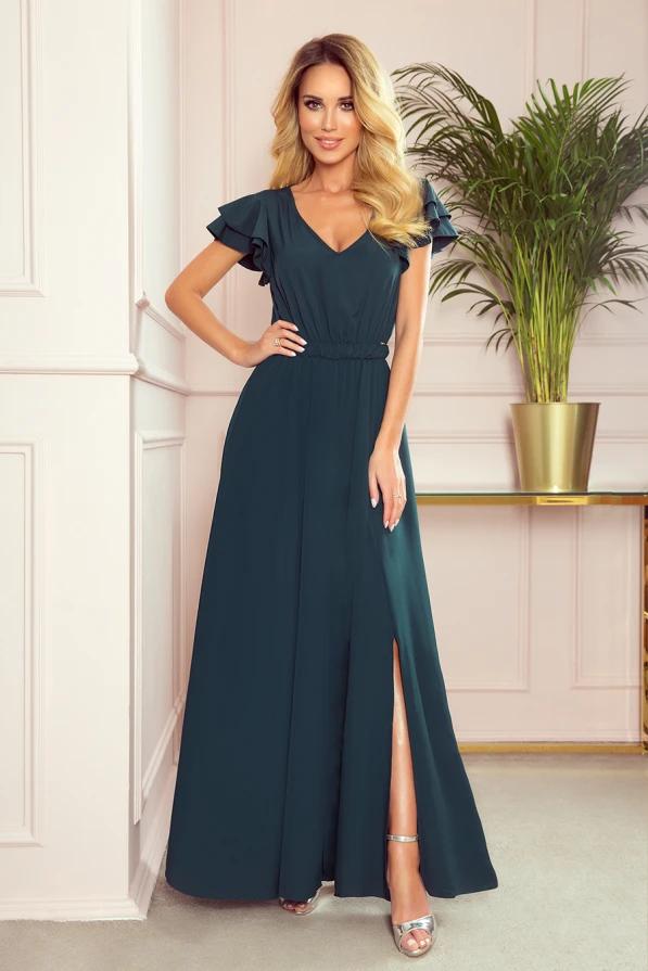 Ilga, elegantiška tamsiai žalia suknelė su V formos iškirpte ir trumpomis rauktomis rankovėmis. Suknelė turi subtilų skeltuką, suteikiantį judesiui lengvumo ir elegancijos.