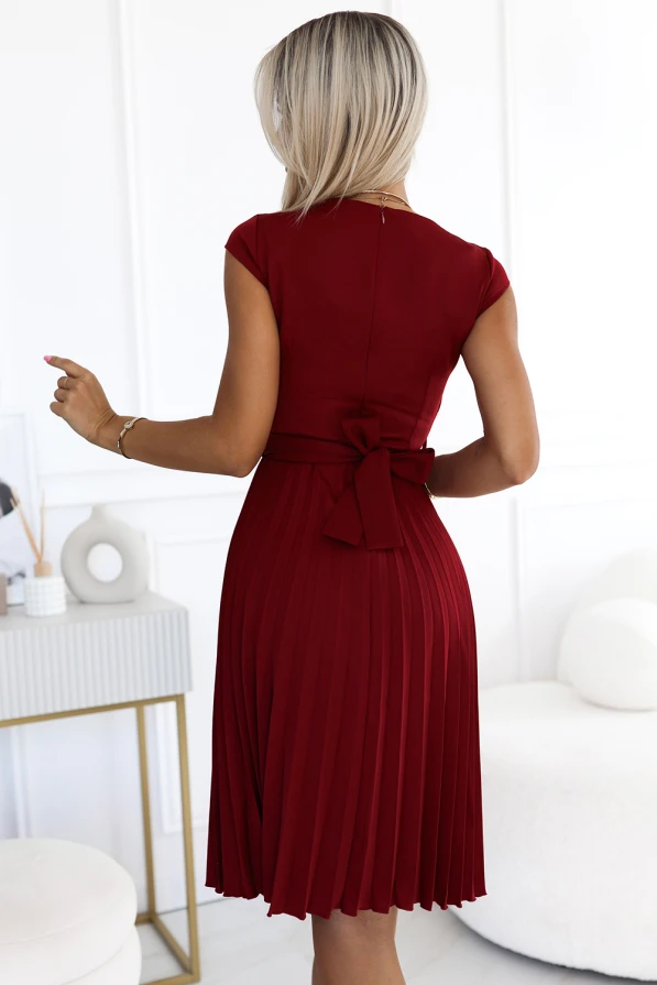 Elegantiška, raudona, plisuota suknelė su kaspinu nugaroje suteikia rafinuotumo ir moteriškumo. Suknelė puikiai tinka ypatingoms progoms ar elegantiškiems vakarėliams.