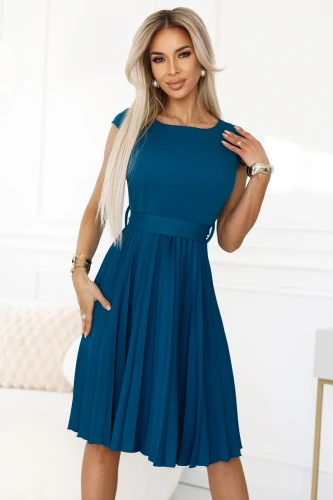 Moteriška suknelė su plisuota apačia ir elegantišku, prigludusiu viršumi, pagaminta iš lengvo, mėlyno audinio. Suknelė turi trumpas rankoves ir subtilų dirželį, pabrėžiantį liemenį.}