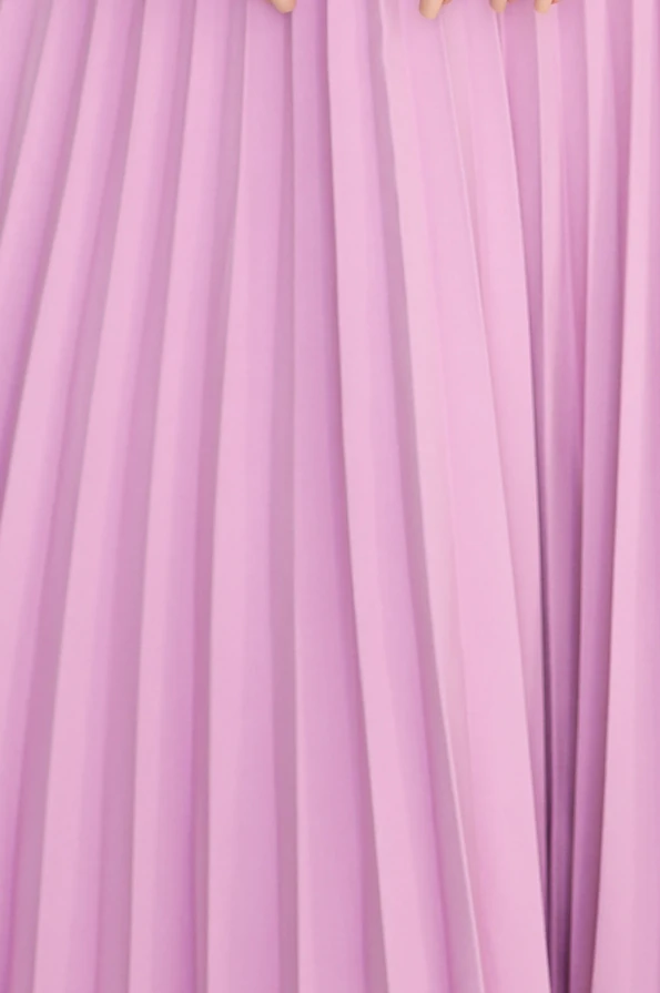 Klasikinė, švelniai violetinė plisuota suknelė su elegantiškomis klostėmis. Suknelė pasižymi lengvumu ir rafinuotumu, puikiai tinka įvairioms progoms.