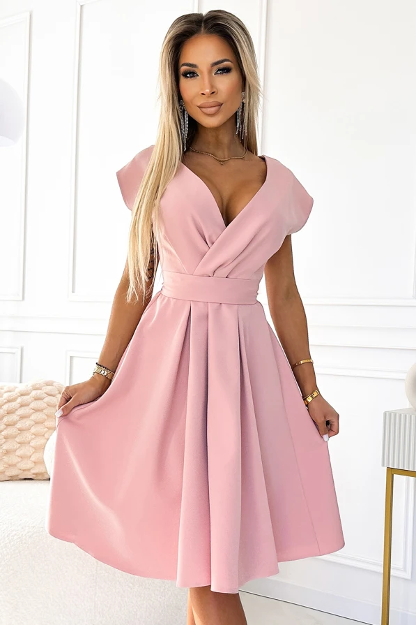 Elegantiška, šviesiai rožinė suknelė su V formos iškirpte ir trumpomis rankovėmis, pabrėžianti moterišką siluetą. Suknelė turi platų, klostuotą sijoną, suteikiantį žaismingumo ir elegancijos.