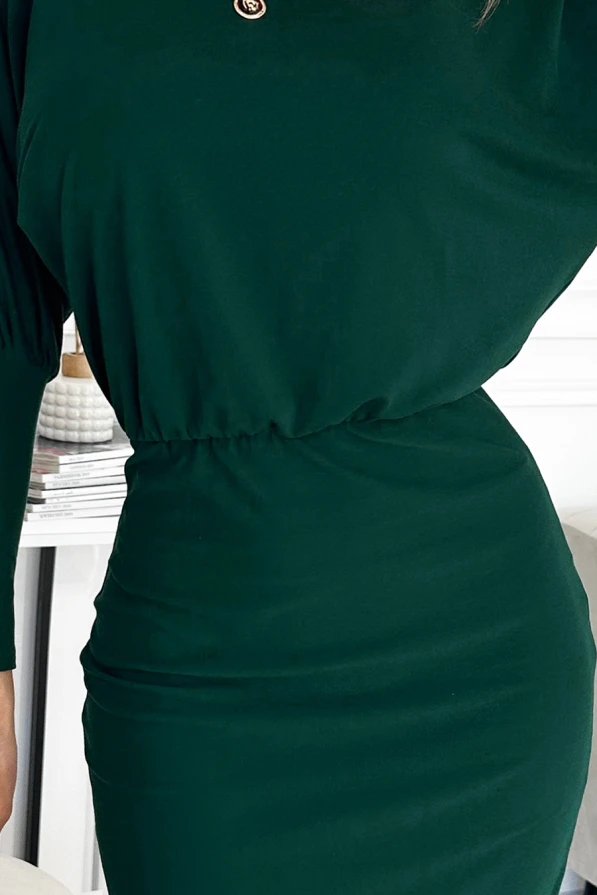Elegantiška tamsiai žalia suknelė su elastinga juosmens dalimi, kuri pabrėžia figūrą. Suknelė turi subtilų, minimalistinį dizainą, puikiai tinkantį įvairioms progoms.