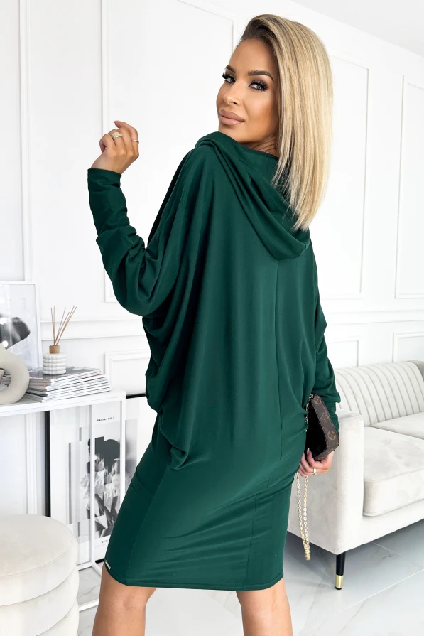 Žalia suknelė su laisvomis rankovėmis ir elegantišku kirpimu suteikia modernų ir stilingą įvaizdį. Audinys atrodo minkštas ir patogus, puikiai tinkantis tiek kasdienai, tiek ypatingoms progoms.