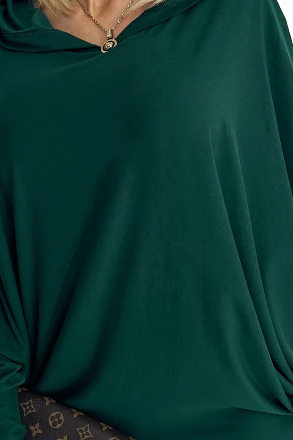 Žalia suknelė su laisvomis rankovėmis ir elegantišku, laisvu kirpimu. Medžiaga atrodo minkšta ir patogi, puikiai tinkanti kasdieniam dėvėjimui.