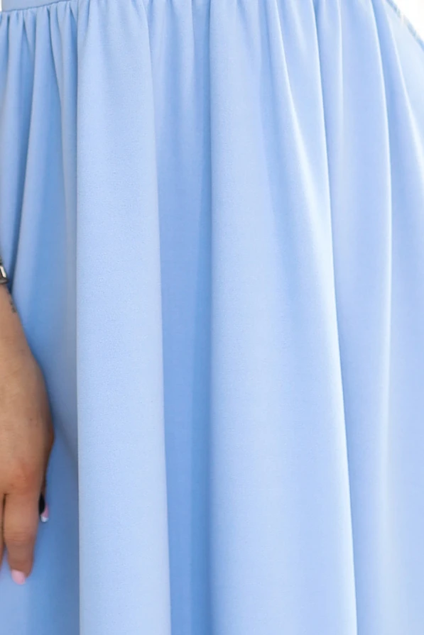 Šviesiai mėlyna suknelė su švelniai krentančiu audiniu ir elegantišku klostavimu. Suknelė suteikia lengvumo ir rafinuotumo įspūdį.