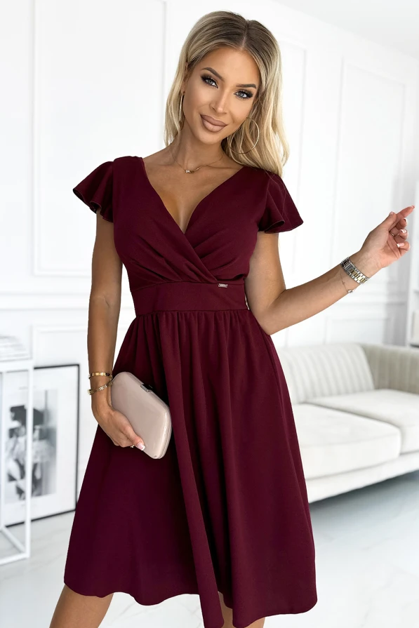 Elegantiška bordo spalvos suknelė su V formos iškirpte ir trumpomis rankovėmis suteikia rafinuotumo ir moteriškumo. Suknelė puikiai tinka tiek kasdienai, tiek ypatingoms progoms, pabrėžiant figūrą ir suteikiant komfortą.