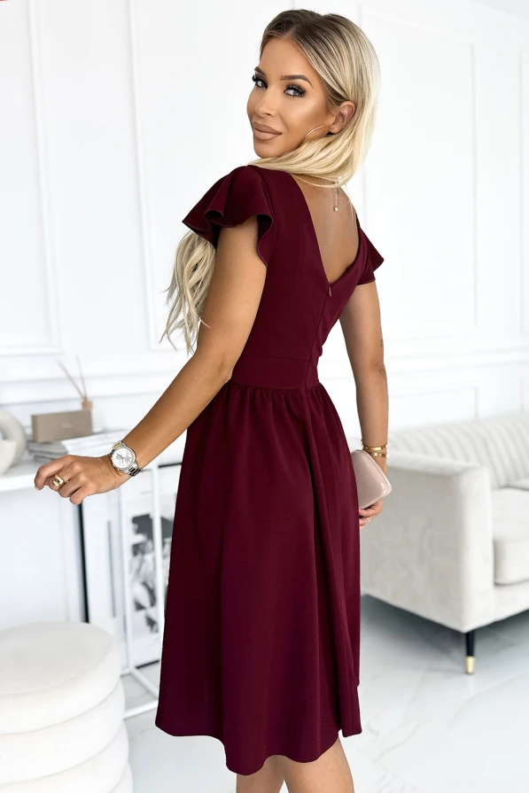 Elegantiška bordo spalvos suknelė su trumpomis rankovėmis ir subtiliu V formos iškirpimu nugaroje. Suknelė puikiai tinka tiek kasdienai, tiek ypatingoms progoms, suteikdama rafinuotumo ir moteriškumo.