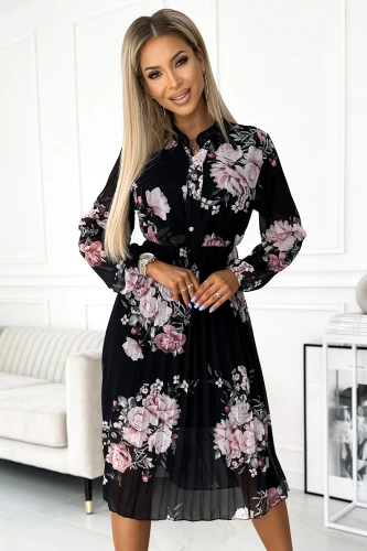 Elegantiška juoda suknelė su ilgomis rankovėmis, dekoruota dideliais rožiniais gėlių raštais. Plisuotas sijonas suteikia lengvumo ir moteriškumo įspūdį.}