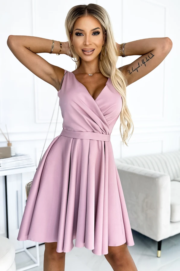 Elegantiška, šviesiai rožinė suknelė su V formos iškirpte ir plonomis petnešėlėmis. Suknelė turi platų sijoną, kuris suteikia lengvumo ir elegancijos.