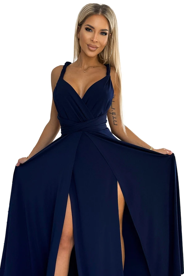 Elegantiška ilga suknelė tamsiai mėlynos spalvos su giliu iškirpimu ir plonomis petnešėlėmis. Suknelė turi elegantišką skeltuką, kuris suteikia žavesio ir rafinuotumo.