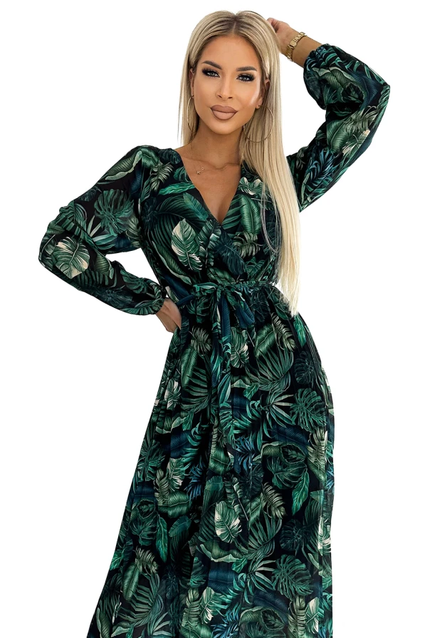 Ilga, plisuota šifoninė suknelė su tropiniu lapų raštu suteikia elegancijos ir lengvumo. Suknelė turi ilgomis rankovėmis ir subtiliai paryškintą juosmenį.