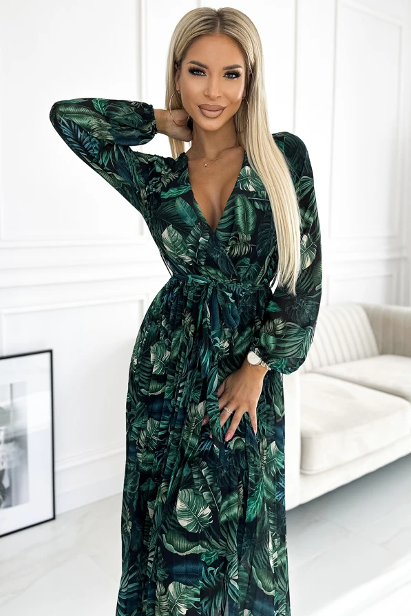 Ilga, plisuota šifoninė suknelė su tropiniu lapų raštu, puikiai tinka elegantiškoms progoms. Suknelė turi ilgomis rankovėmis ir surišama juosmenyje, suteikiant figūrai grakštumo.