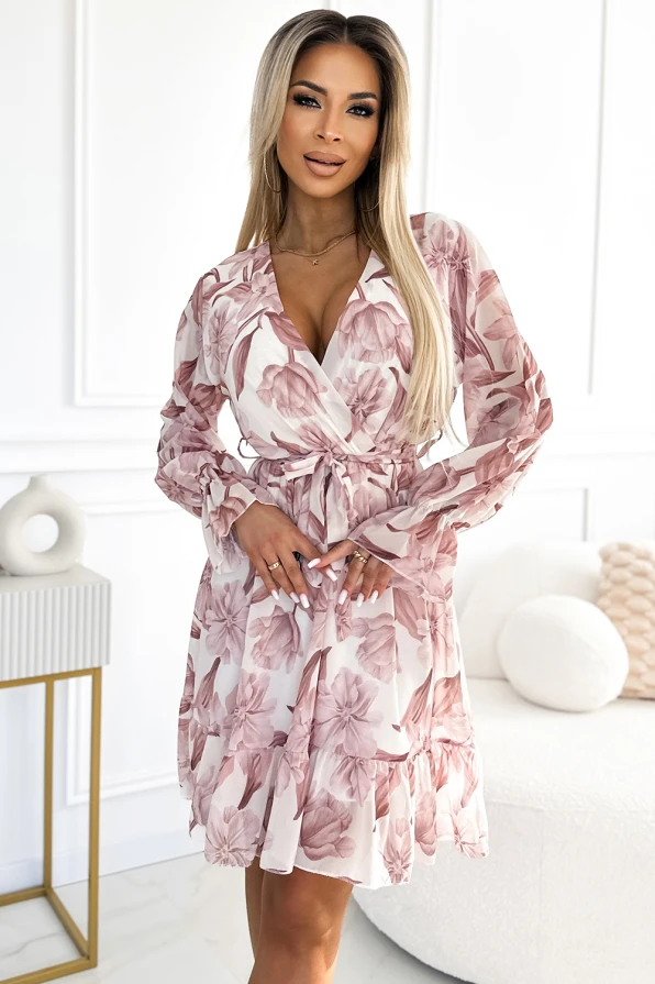 Elegantiška šifoninė suknelė su subtiliu gėlių raštu ir ilgomis rankovėmis. Suknelė turi V formos iškirptę ir juosmenį pabrėžiantį dirželį.