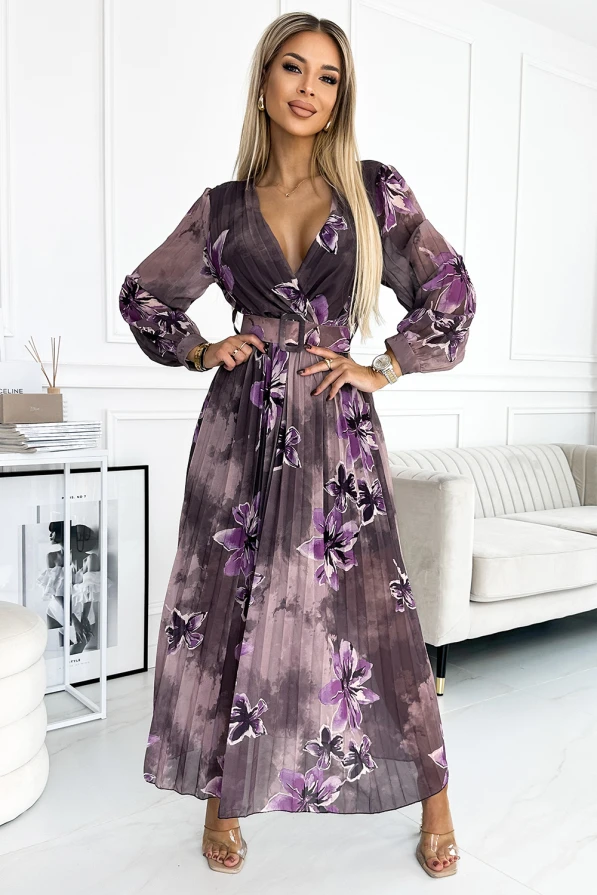Ilga, plisuota šifoninė suknelė su violetiniais gėlių raštais suteikia elegancijos ir lengvumo. Suknelė turi V formos iškirptę ir ilgomis rankovėmis, puikiai tinkančią ypatingoms progoms.