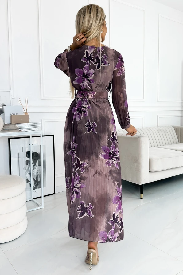 Ilga, plisuota šifoninė suknelė su ilgomis rankovėmis ir violetiniais gėlių raštais suteikia elegancijos ir lengvumo. Suknelė puikiai tinka tiek kasdieniam dėvėjimui, tiek ypatingoms progoms.
