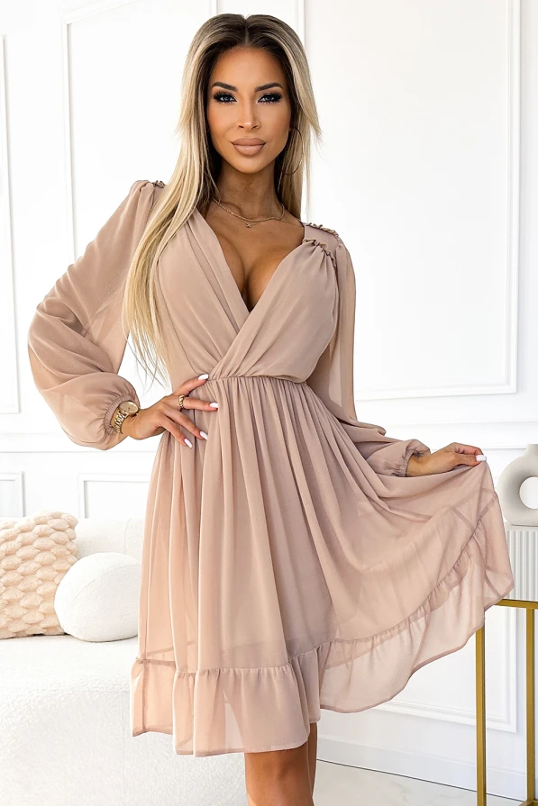 Elegantiška šifoninė suknelė su ilgomis rankovėmis ir subtiliu klostavimu apačioje. Suknelė pasižymi švelnia smėlio spalva ir elegantišku V formos iškirpimu.